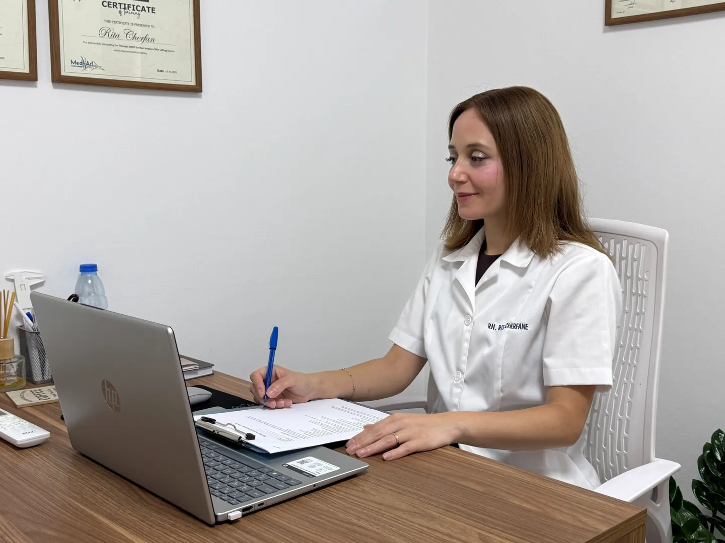 Rita writing notes at the clinic consultation desk